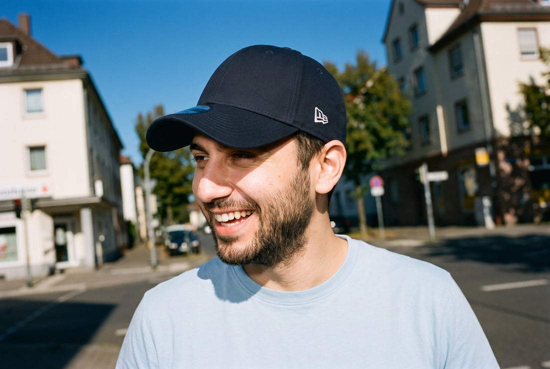 Lachender Mann mit marineblauer New Era 9FORTY, klassisch mit dem Schirm nach vorn getragen